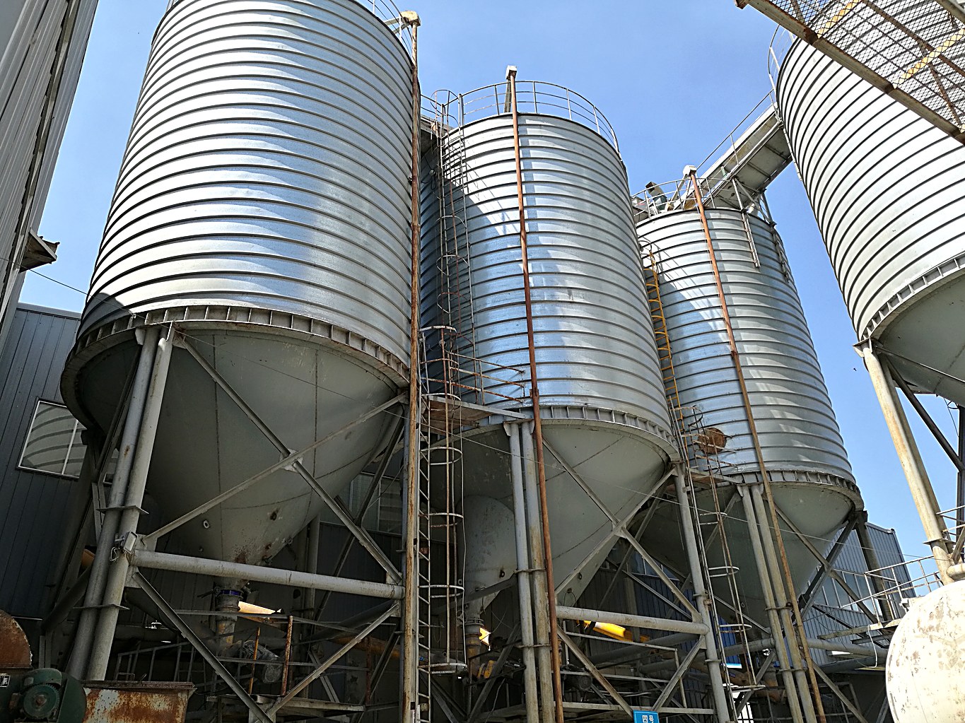 Cone-bottom steel silo with steel support structure for abrasive fine aggregate