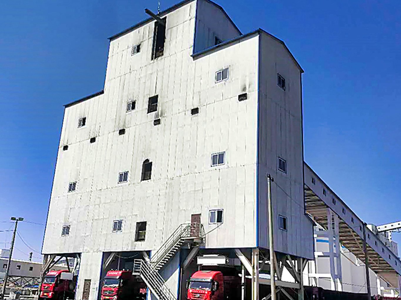 Bulk truck loading bay receiving material discharged from storage silos